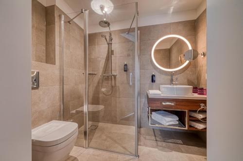 灵斯海姆FourSide Hotel Ringsheim的带淋浴、卫生间和盥洗盆的浴室