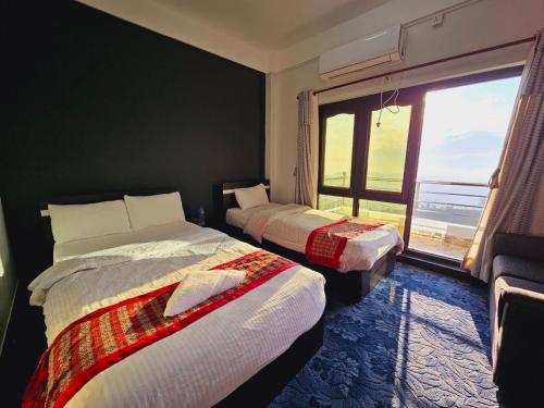 纳加阔特Hotell Hill Crown的带大窗户的客房内的两张床