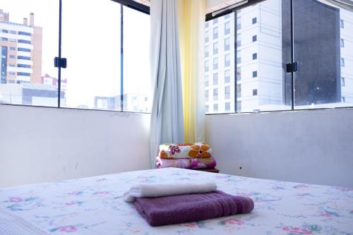 蓬塔格罗萨Apartamentos na região Central Cobertura e 2 quartos的一间卧室设有一张床和一个大窗户