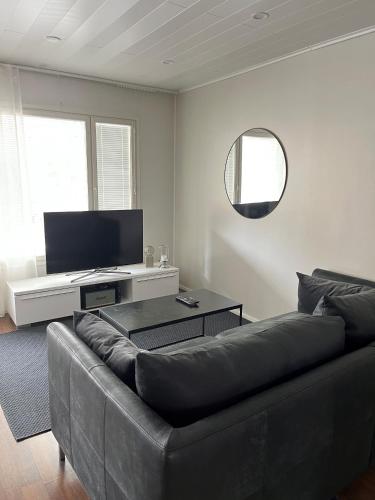 LehmonahoRauhallinen paritalo, Sauna, Terassi, Grilli的客厅配有黑色沙发和平面电视。