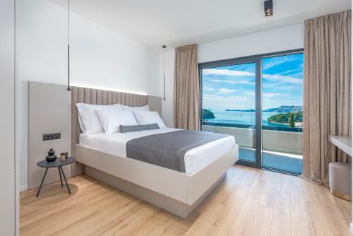 察夫塔特"Villa AnMari" The Cavtat View Residence的一间卧室设有一张大床和一个大窗户