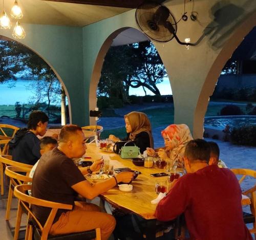 哲帕拉La Collina Villa的一群人坐在木桌旁