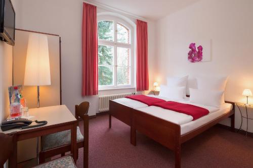 柏林镇公所酒店的一间卧室配有一张床、一张书桌和一个窗户。