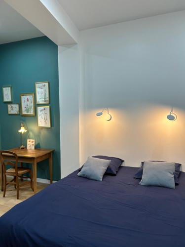 迪耶普Magnifique Appartement l'Aigrette的蓝色卧室配有一张床和一张书桌