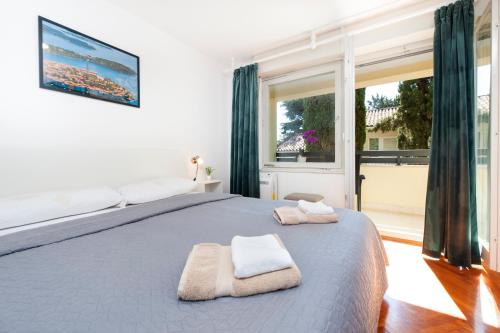 罗维尼Casa Caterina的一间卧室配有一张大床和毛巾