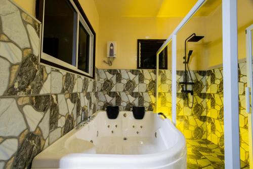 洛博克Loboc Cool River Resort的浴室设有白色水槽和马赛克瓷砖。