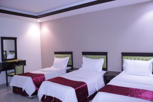 吉达Altamyoiz Sirved Apartments的酒店客房设有两张床和钢琴