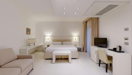 奥斯图尼蒙特萨拉戈酒店的白色卧室配有床和沙发