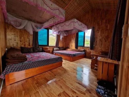 萨帕Ta Van Heaven Homestay的一间大型卧室,配有两张床和窗户