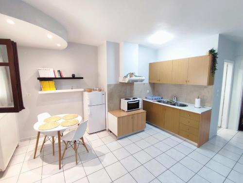 普雷韦扎Palmeira Studio的厨房配有桌子、水槽和冰箱