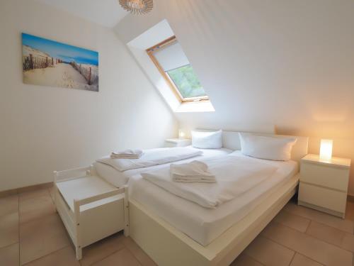 赛巴特班森Haus Auguste - App. 16的一间白色卧室,配有两张床和窗户
