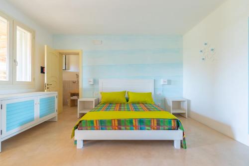 圣卡特琳娜迪纳德Cava Li Santi Residence的一间卧室配有一张带彩色毯子的床