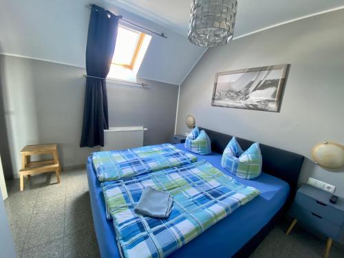 宾茨Haus Sonnenhügel的一间卧室设有蓝色的床和窗户。