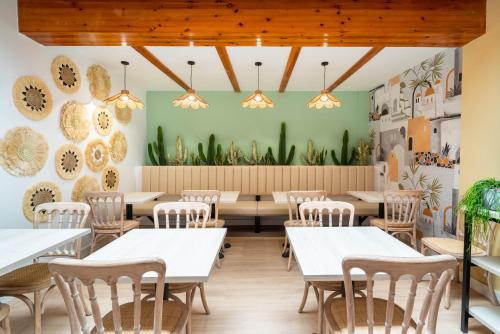 卡沃内拉斯BF Rooms Carboneras的一间设有白色桌椅的用餐室