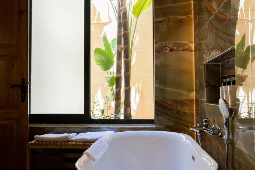 维多利亚Razzett Ziffa的带浴缸的浴室和种植了植物的窗户