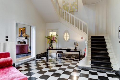 安特卫普Small Luxury Hotel De Witte Lelie的一间带楼梯和 ⁇ 板的客厅