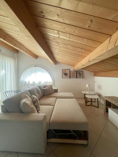 利多迪耶索罗VILLA EMMA -WALTERIGATO Apartments SOLO PER FAMIGLIE的客厅设有大沙发和木制天花板