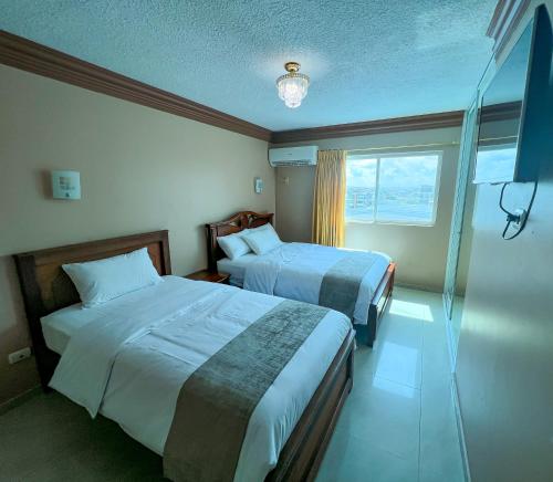 曼塔Apart Hotel Hamilton的酒店客房设有两张床和窗户。
