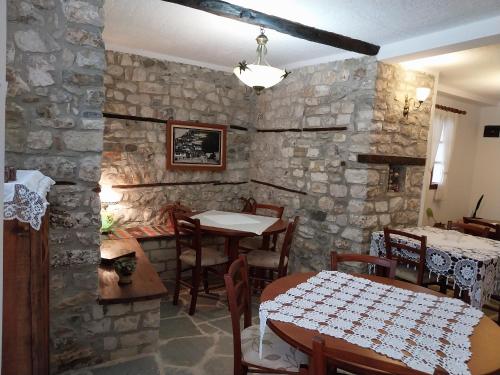 培拉特Guest House J.Prifti的一间设有桌子和石墙的用餐室