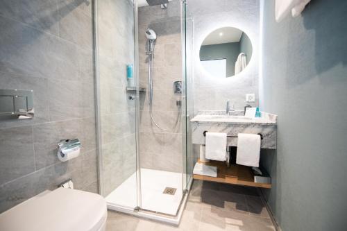 阿斯科纳Ascona Lodge, Pool & Garden Retreat的带淋浴、卫生间和盥洗盆的浴室
