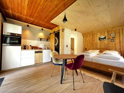 马尔尼茨Mallnbach Apartments的卧室配有一张床和一张桌子及椅子