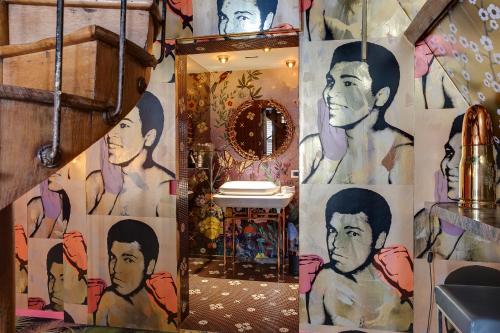 安特卫普Small Luxury Hotel De Witte Lelie的浴室设有挂有男性画作的墙壁