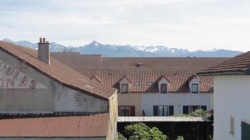 塔布Petit cocon Tarbais -wifi-parking的一组背景为山脉的建筑