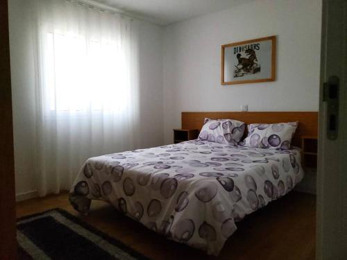 法蒂玛Monte dos Pastorinhos的一间卧室配有一张带床罩的床和窗户