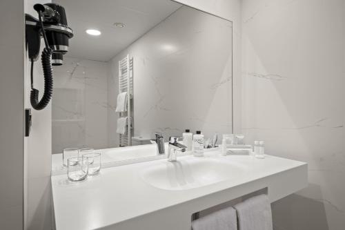 奥维多Hotel Zentral Ramiro I Oviedo的白色的浴室设有水槽和镜子