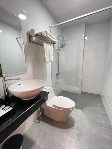 波来古市Hotel Hoàng My的浴室配有卫生间、盥洗盆和淋浴。