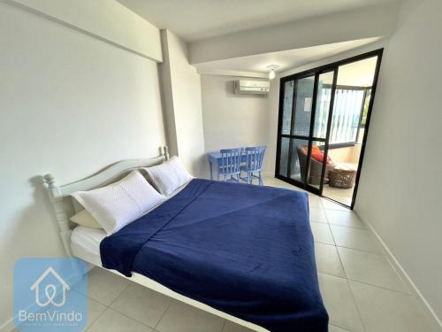 萨尔瓦多Apartamento completo e pé na areia no Rio Vermelho的一间卧室配有一张带蓝色毯子的床