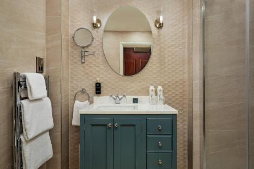 基拉尼麦克罗斯公园酒店及水疗中心的一间带绿色橱柜和镜子的浴室