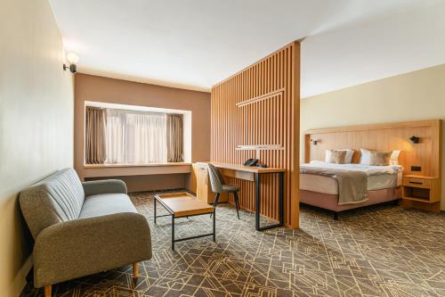 PaşcaniHOTEL CENTRAL的酒店客房配有床、沙发和椅子