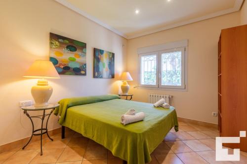 卡尔佩Villa Coral - Grupo Turis的一间卧室配有绿床和2条毛巾