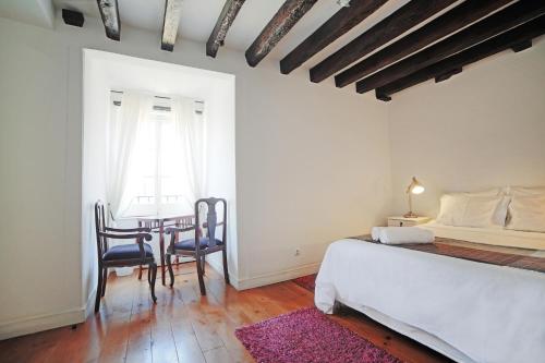 里斯本Rossio Hostel的卧室配有一张床和一张桌子及椅子