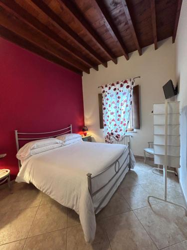皮恩扎Valdorcia Belvedere b&b的卧室配有白色的床和红色的墙壁