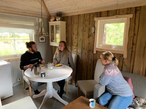 KokelvModern turf house的一群人坐在一个房间里桌子旁