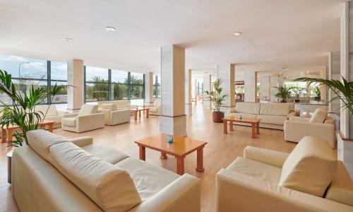 帕尔马海滩陶鲁斯公园集团酒店的客厅配有白色家具和大窗户