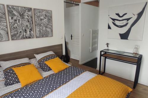 勒阿弗尔Tendance et Charmant F2的一间卧室配有一张带黄色枕头和桌子的床