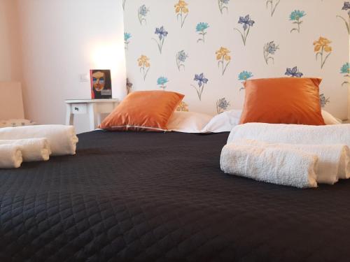 圣安蒂奥科B&B La Jacaranda affittacamere的一张带橙色和白色枕头的床
