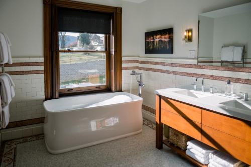 伯利恒Wilbur Mansion的带浴缸、水槽和窗户的浴室