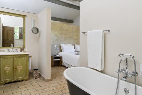 加尔加斯Coquillade Provence的带浴缸的浴室和1间带1张床的卧室