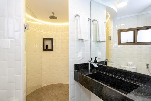圣保罗Travel Inn Paulista Wall Street的一间带水槽和玻璃淋浴的浴室