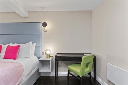 伦敦London's boutique studio的一间卧室配有一张床和一张带绿椅的书桌