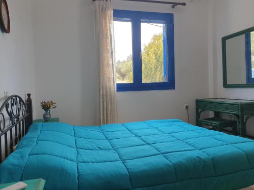 阿彻奇洛斯Sunset Holiday House的卧室内的一张蓝色的床,卧室设有窗户