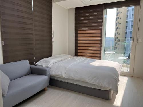 仁川市THE TiME的一间卧室配有一张床、一张沙发和一个窗口