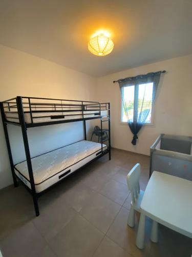 苏亚克Vacances Vallée de la Dordogne的一间卧室设有两张双层床和一张桌子