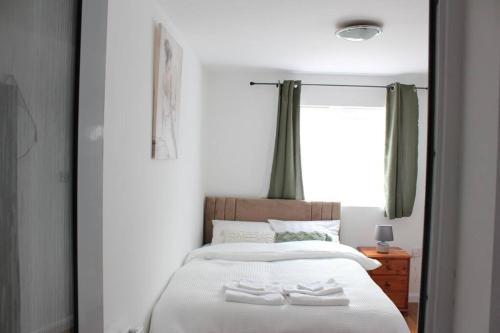 埃尔特姆Self-contained guest suite的一间卧室配有一张带两条白色毛巾的床