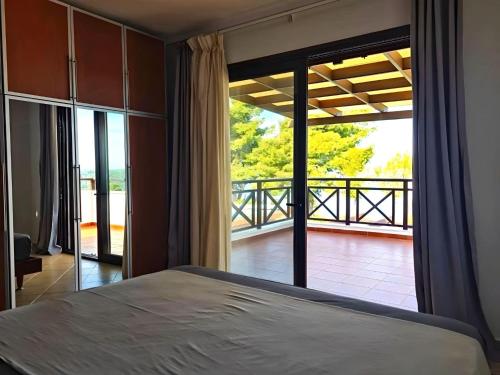 希维利Sunset Villa的一间卧室设有一张床,享有阳台的景色
