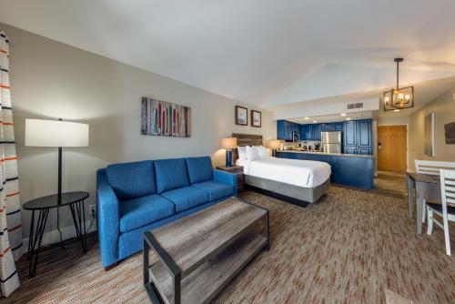 帕克城Raintree's Park Plaza Park City的酒店客房,配有床和蓝色的沙发